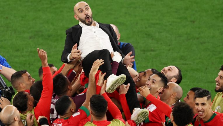 Morocco head coach Walid Regragui is thrown into the air in celebration by his players