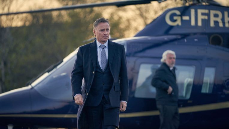 Robert Carlyle getting out of a helicopter as Robert Sutherland, the PM, in Sky One's COBRA